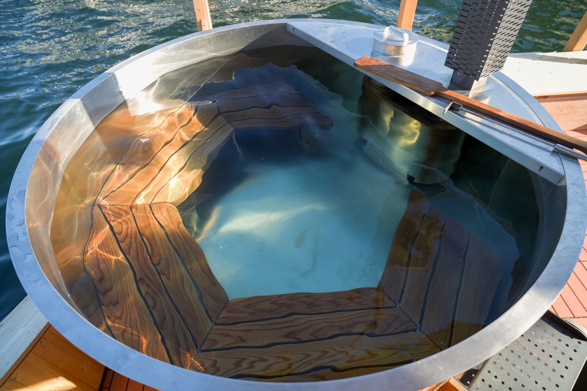Looking down into the round wood-fired hot tub filled with clear water